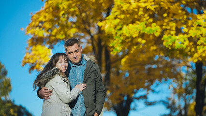Fototapeta premium Happy couple enjoying a romantic moment together in a vibrant autumn park, surrounded by golden leaves
