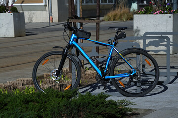 Fototapeta premium Bright blue bicycle on the parking lot of the bicycles in the urban environment