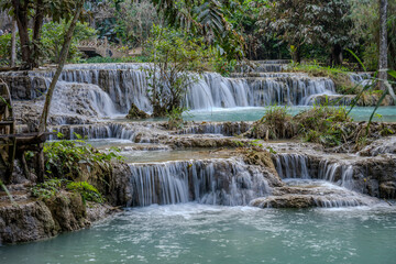 Obraz premium Terraced Waterfalls and Turquoise Pools at Kuang Si Falls with Lush Jungle Surroundings near Luang Prabang, Laos