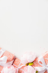 Chic pink gift boxes with peonies and white ribbons on a white background. Happy Mother's Day vertical banner design.