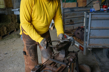 working on an anvil, some horseshoes to put on the horse, with different work tools