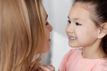 Mother And Daughter Relationship. Happy Kid Girl Holding Hands With Mom Looking At One Another Indoors. Selective Focus