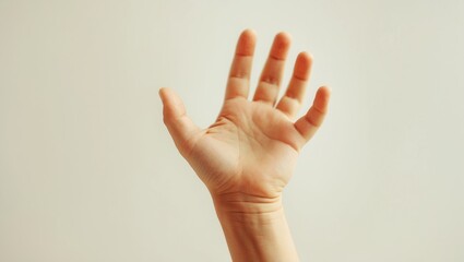 Closeup of a child's hand making a vertical gesture against a white background.