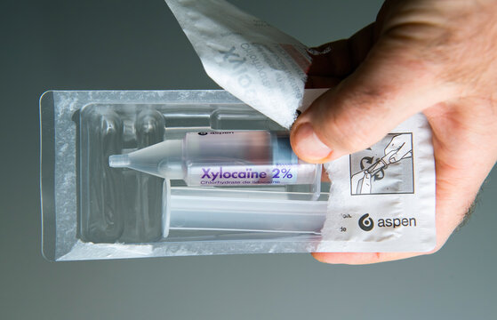 Paris, France - Mar 10, 2025: A close-up of a hand holding a package of Xylocaine 2 percent, a local anesthetic, showcasing the syringe and detailed product information.