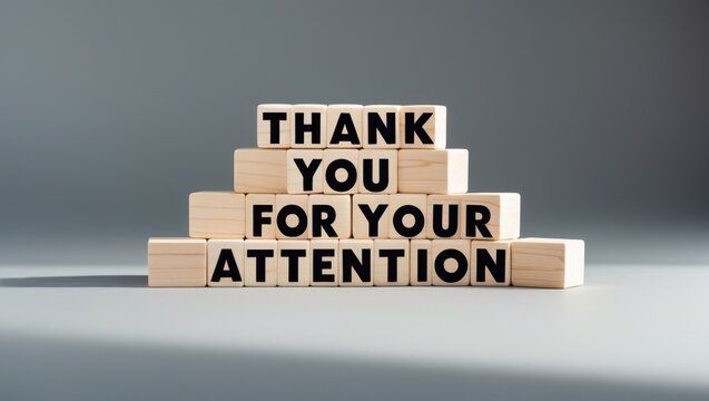 Attention symbol. Stacked wooden blocks feature the message Thank you for your attention against a stylish grey background. Business concept. Space for text.