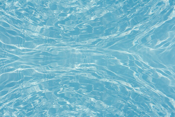 Blue water with ripples on the surface. Defocus blurred transparent blue colored clear calm water surface texture with splashes and bubbles. Water waves with shining pattern texture background.