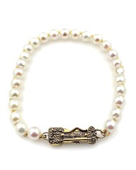 Obraz premium A gold and white pearl necklace with a gold clasp