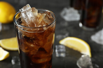 Fresh iced cola and lemon slices on dark grey table, closeup. Space for text