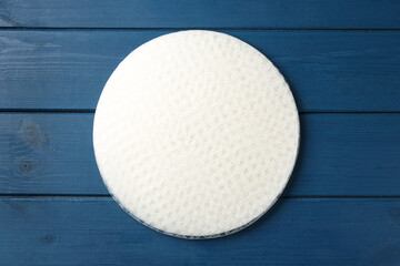 Stack of edible rice paper sheets on blue wooden table, top view