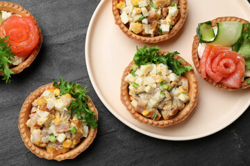 Tartlets with delicious fillings on black table, top view