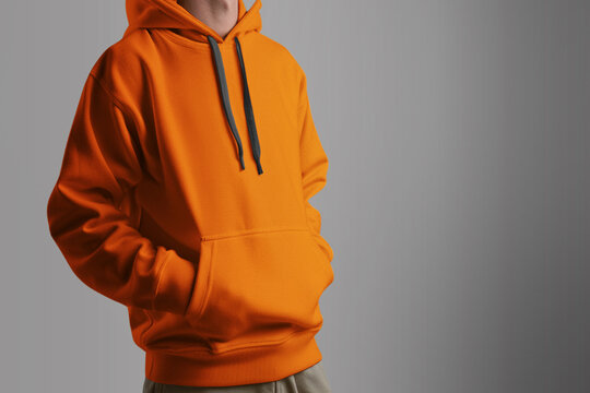 Man wears orange hoodie. no face isolated clothing mockup studio photo.
