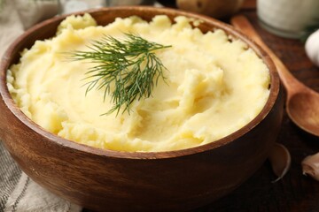 Delicious mashed potato with dill served on wooden table, closeup