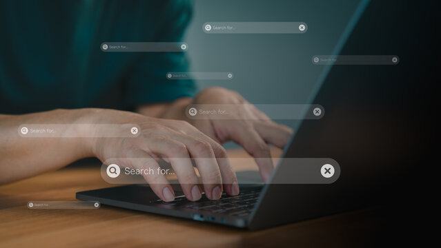 Focusing on a search bar with a magnifying glass icon. Concept of represents online searching, research, and digital information gathering. Male hand types on a laptop keyboard.