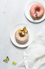 Overhead view of glazed donuts on a white countertop, top view of homemade pastel doughnuts, process of making Easter glazed doughnuts