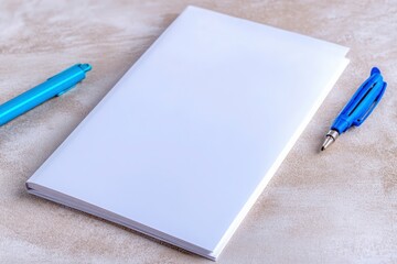 Blank Notebook and Blue Pens on Soft Gray Background