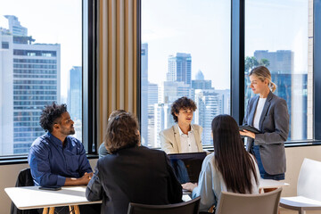 Caucasian woman sale manager is showing annual report chart to her colleagues in executive meeting...