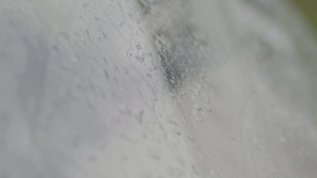 Drops of water from the rain close-up on the glass on a cloudy day