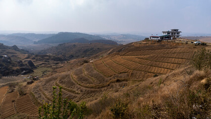 Shot of rocky hills with terrace cultivation with house at Laitlum in Meghalaya India 2