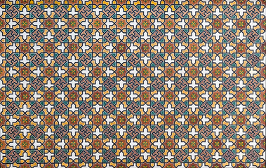 A detailed shot of a traditional wooden geometric pattern with vibrant colors, inspired by Islamic and Middle Eastern art. Ideal for backgrounds, interior decor, and architectural elements.