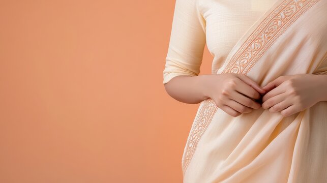 Elegant ivory muslin saree with intricate chikan embroidery, styled gracefully against warm peach background
