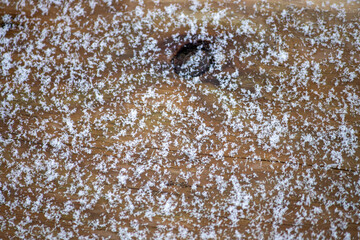 A knotty wooden board with snowflakes - close-up