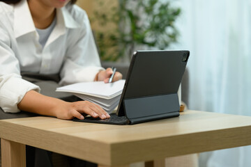 Close up shot unrecognizable woman typing on a digital tablet keyboard