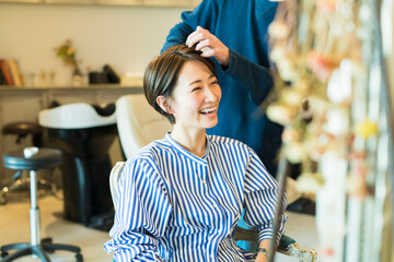 美容室でヘアカットをしてもらう30代女性