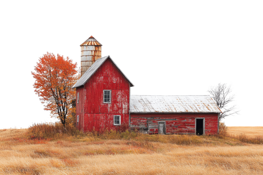 A rustic red barn surrounded by golden fields and autumn trees under a clear blue sky.