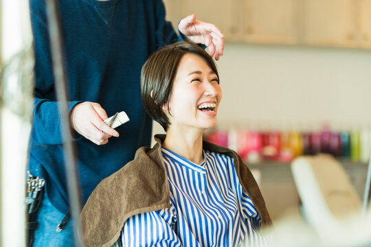 美容室でヘアカットをしてもらう30代女性