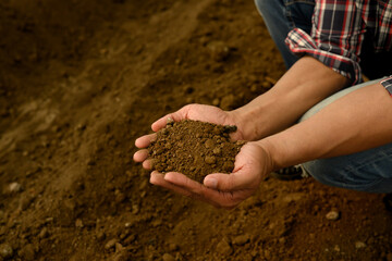 Farmer inspecting soil texture and composition, preparing for planting