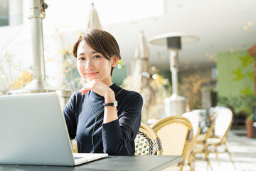 カフェでリモートワークをする30代日本人女性