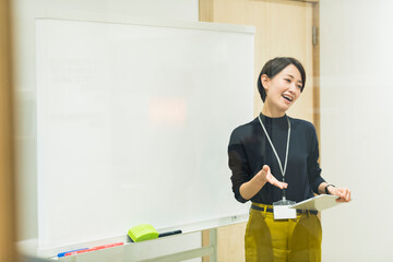 会議室でプレゼンをする30代日本人女性