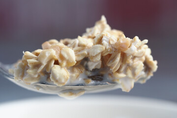 Warm bowl of oatmeal topped with nuts and honey in morning light