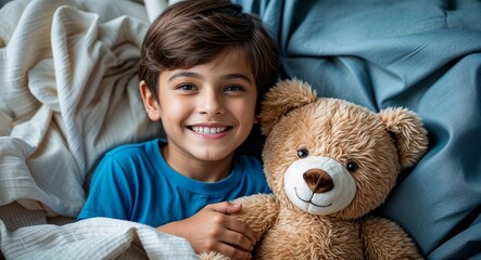 Smiling brown haired boy in blue t shirt hugging teddy bear kindergarten nap time photography model