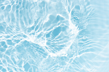 Blue water with ripples on the surface. Defocus blurred transparent blue colored clear calm water surface texture with splashes and bubbles. Water waves with shining pattern texture background.