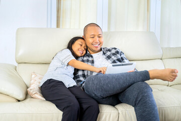 Obraz premium Father and daughter bonding while using a digital tablet at home