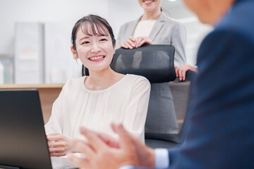 笑顔で上司の話を聞く若いビジネスウーマン