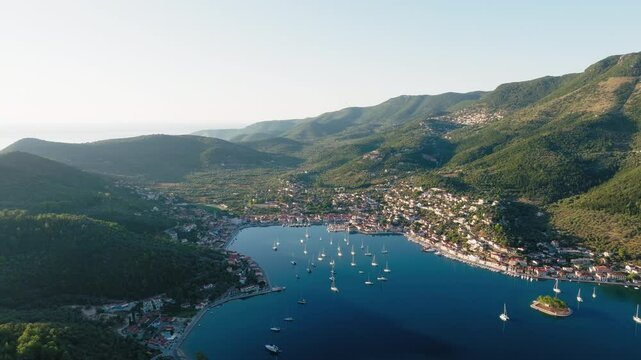 Aerial view of a sailboats moored in the picturesque port of Vathy village during sunrise, Ithaca island, Greece