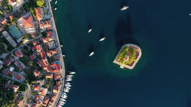 Top down drone shot of small islet of Lazareto in the middle of the port of Vathy village, Ithaca island, Greece