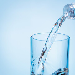Crystal clear water being poured into a transparent glass, creating refreshing ripples and bubbles