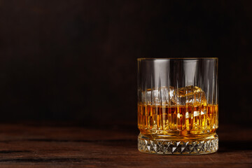 A classic whiskey glass filled with golden amber whiskey