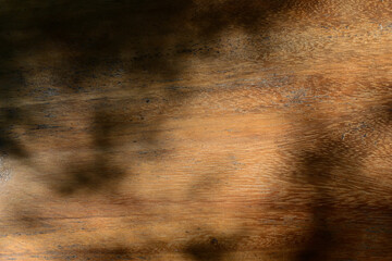 Top view of empty wooden table with shadows leaves. Natural texture in harmonious wood. brown wood...