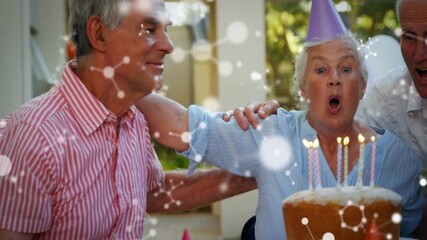 Celebrating birthday with cake, elderly people with animation of molecular structure