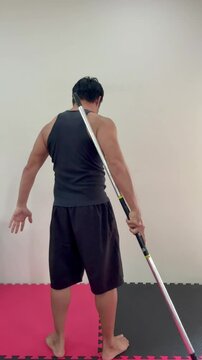 A strong man spining bo staff at back , 4K video.