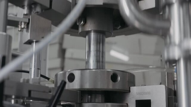 Close-up of part of factory production conveyor. Automatic operation of mechanism. Packaging machine in factory.