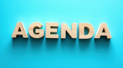 Creative wooden typography displaying agenda on vibrant blue background studio environment modern concept