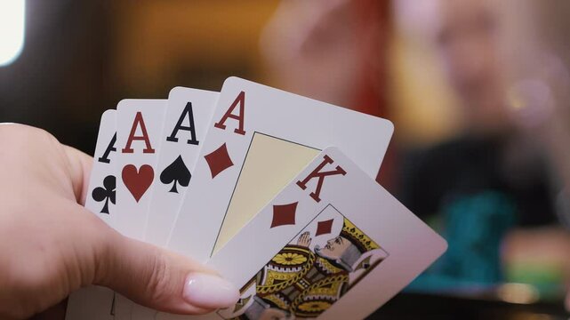 Close up of poker hand showing four aces and a king at a casino table.
