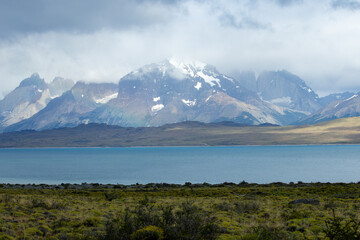 Naklejka premium Lake Sarmiento and the iconic granite peaks of Torres del Paine can just be seen behind the clouds.