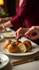 A stylish office event where hands serve truffle butter brioche. Porcelain plates and warm lighting create a luxurious, refined atmosphere.