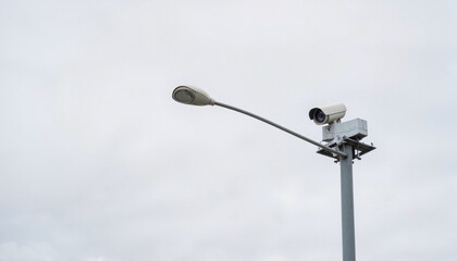 Traffic monitoring camera on isolated post under overcast sky, surveillance technology